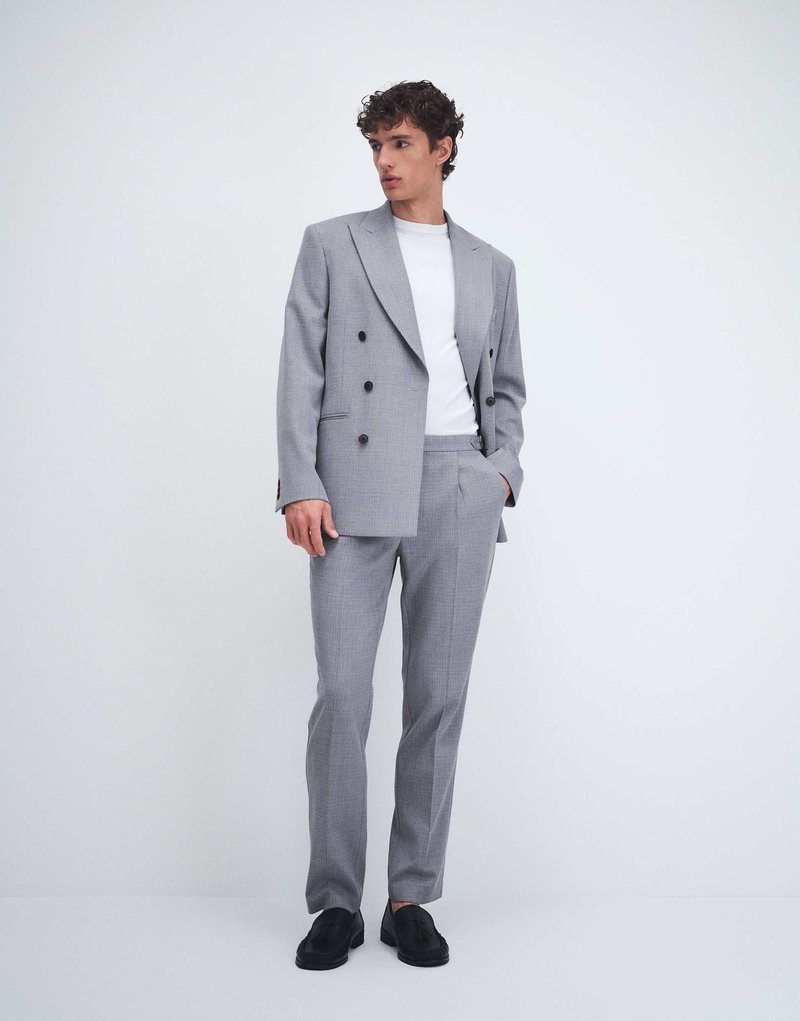 Real photo, model in a double-breasted suit against a plain studio background