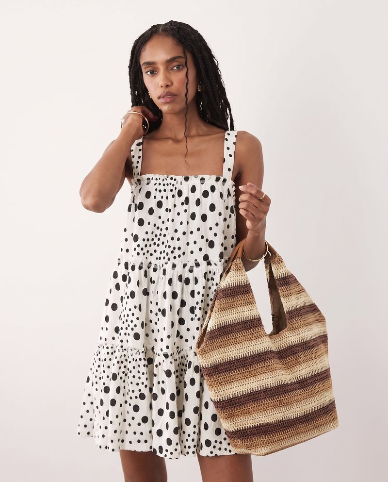 AI-generated variation, same dress styled with a woven tote bag